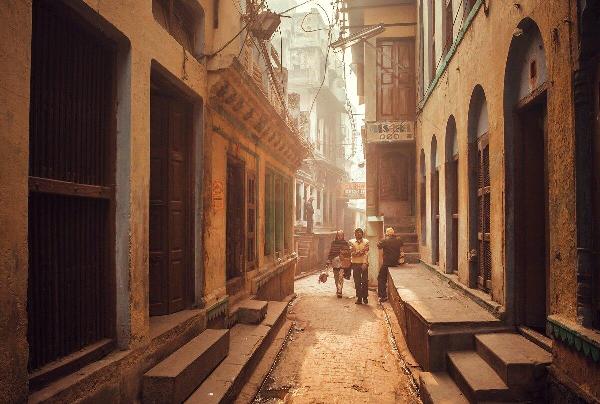 Narrow winding lane in the old quarter of Varanasi lined with shops